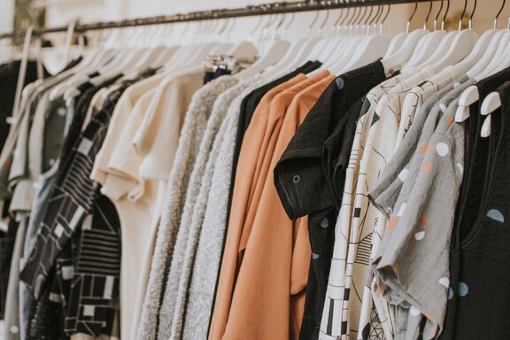 Kleidung hängt in Geschäft | © Photo by Lauren Fleischmann on Unsplash