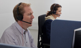 Miterabeitende des Customer Service telefonieren über Headset.