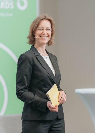 Moderatorin Gudrun Ghezzo lächelt in die Kamera.